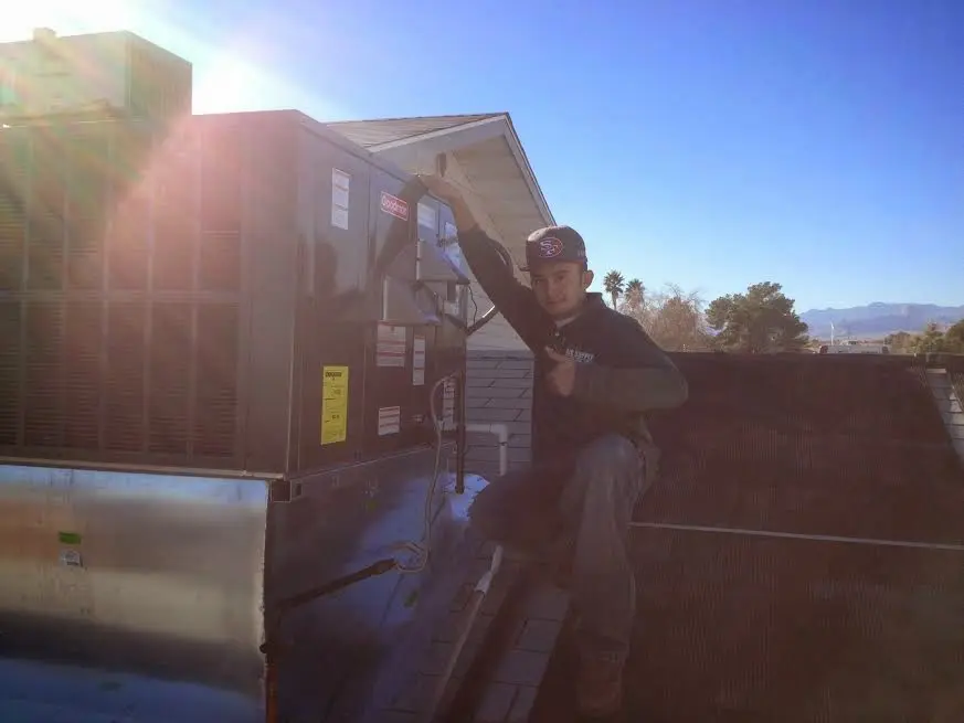 HVAC technician performing Heat Pump Repair on a rooftop unit in Battle Creek